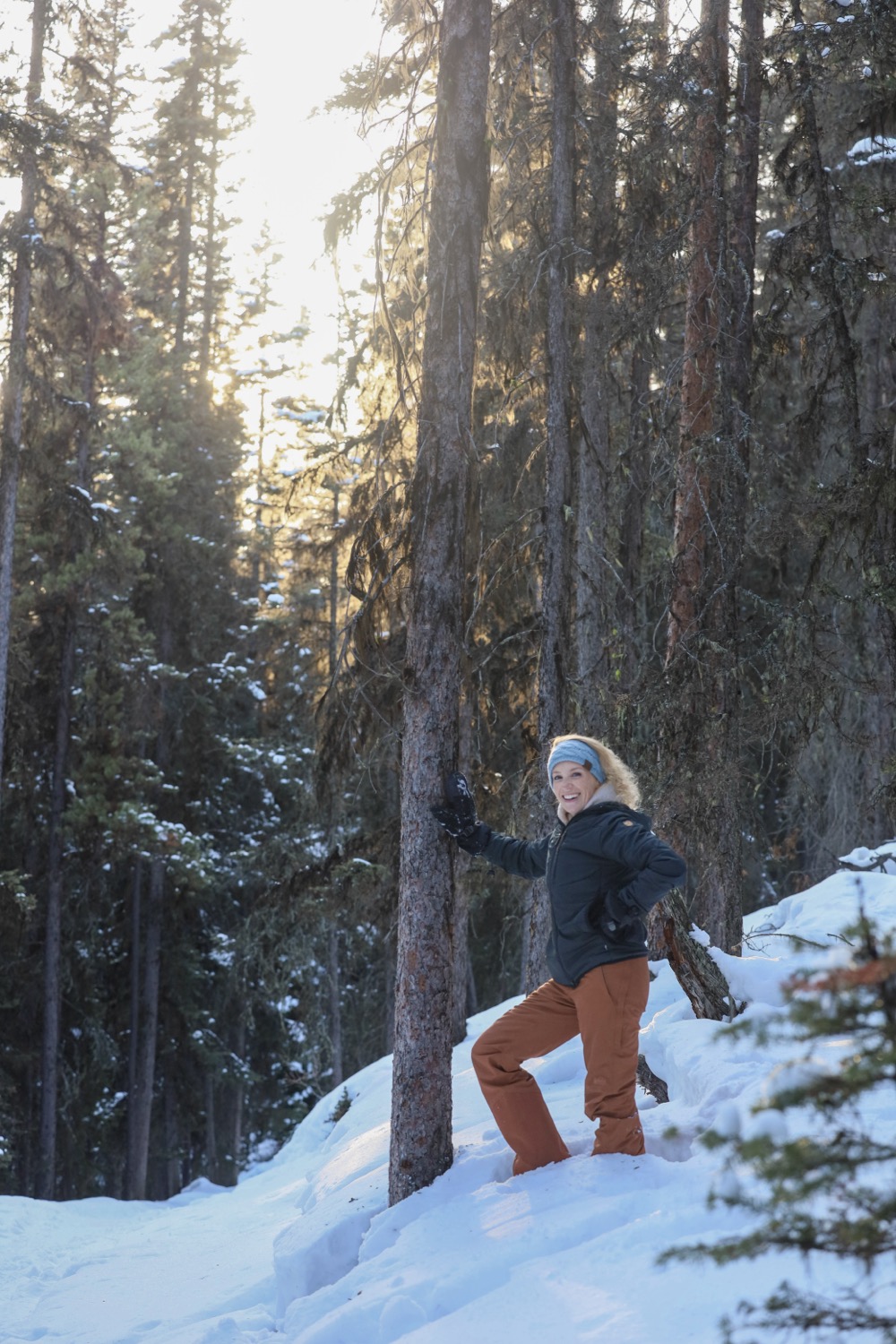 Elyse Hartnett among backlit pines in the snow